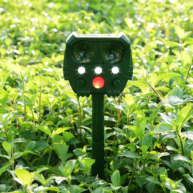 Green solar-powered ultrasonic dog and pest repeller unit for outdoor garden use.