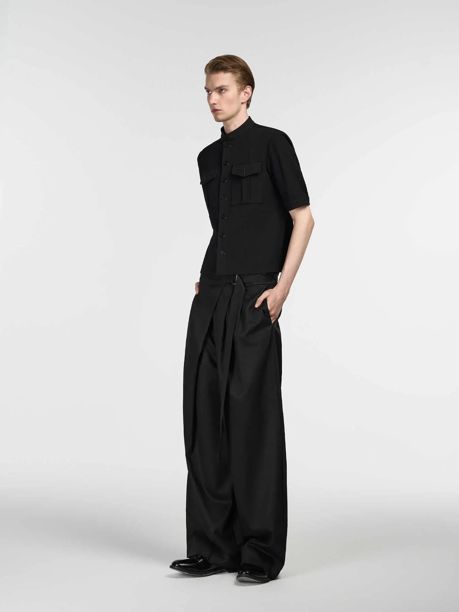 Black straight-leg trousers with a single pleat and adjustable waistband on a neutral background.