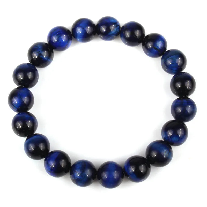 Natural tiger eye crystal bracelet with round beads in various colours on a wrist.