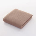 All-cotton jacquard bath towel in beige, 70x140cm, folded on a bathroom shelf