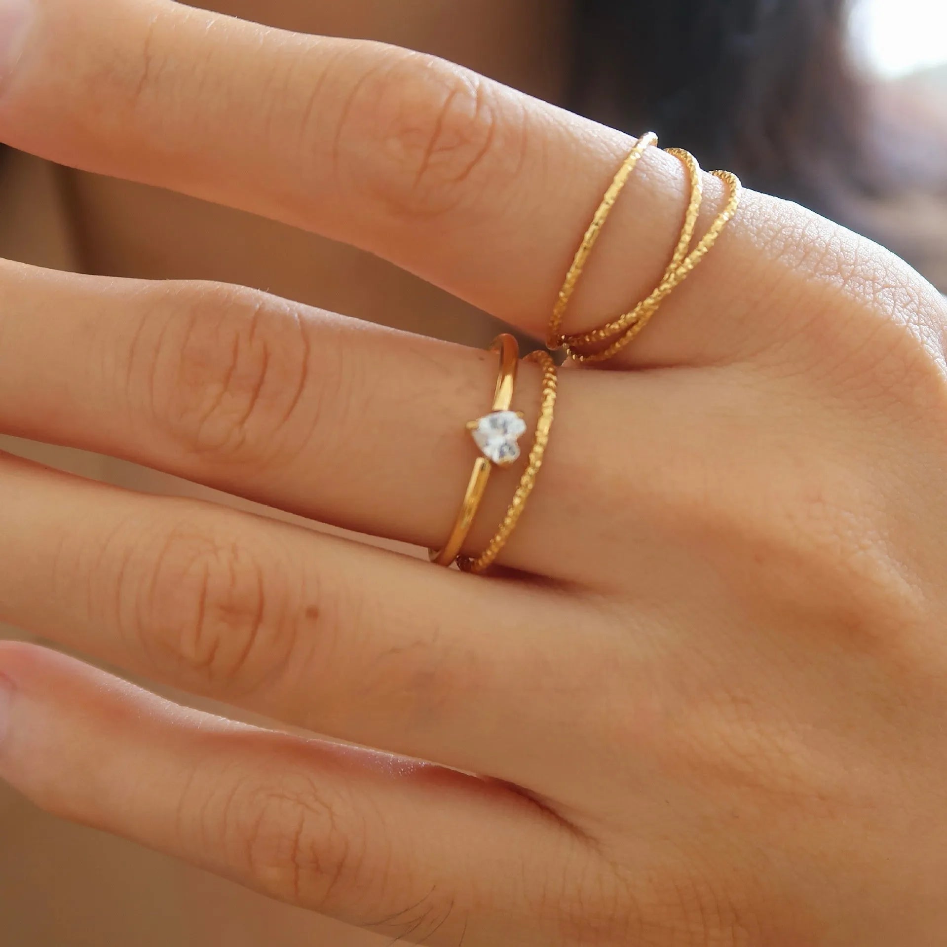 Golden love heart stainless steel ring on finger showing heart-shaped design element