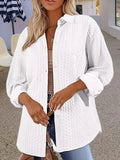 Women's solid colour knitted cardigan with contrast detailing in black, worn open over a white top