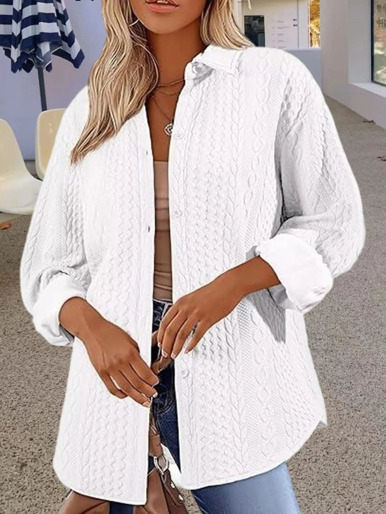 Women's solid colour knitted cardigan with contrast detailing in black, worn open over a white top