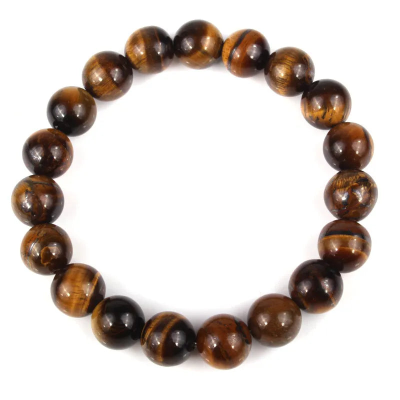 Natural tiger eye crystal bracelet with round beads in various colours on a wrist.