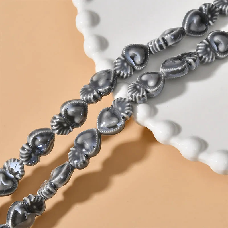 Assorted small ceramic torch beads in multiple colours on a white background.
