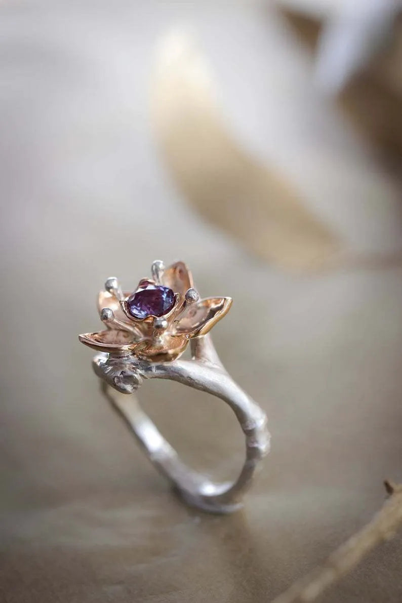 Silver two-tone floral geometric alloy ring for women on a grey background, showing detail.