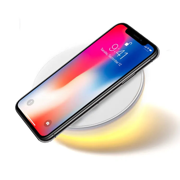 White wireless charger with digital clock display showing time and charging smartphone
