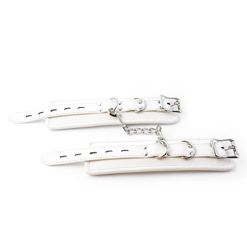 White PU sponge bondage set showing handcuffs, foot cuffs, and neck scarf arranged together