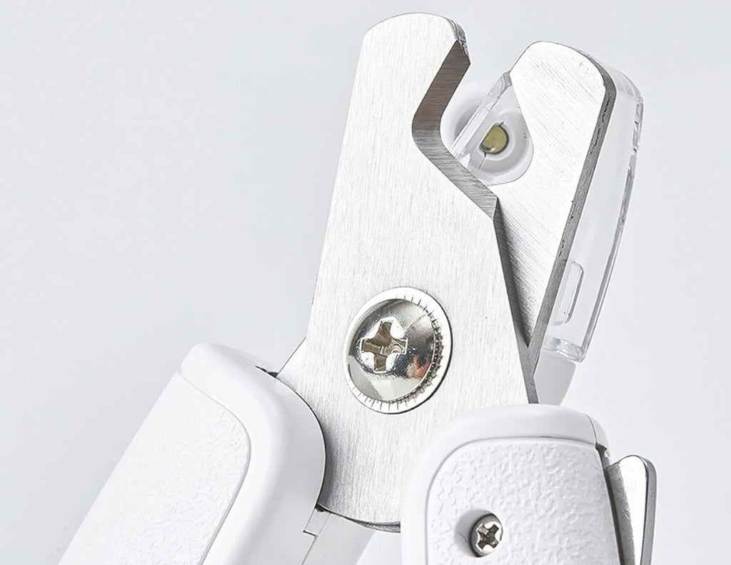 White pet nail clippers with LED light, anti-splash transparent guard, and a leather-like handle on a blue background.