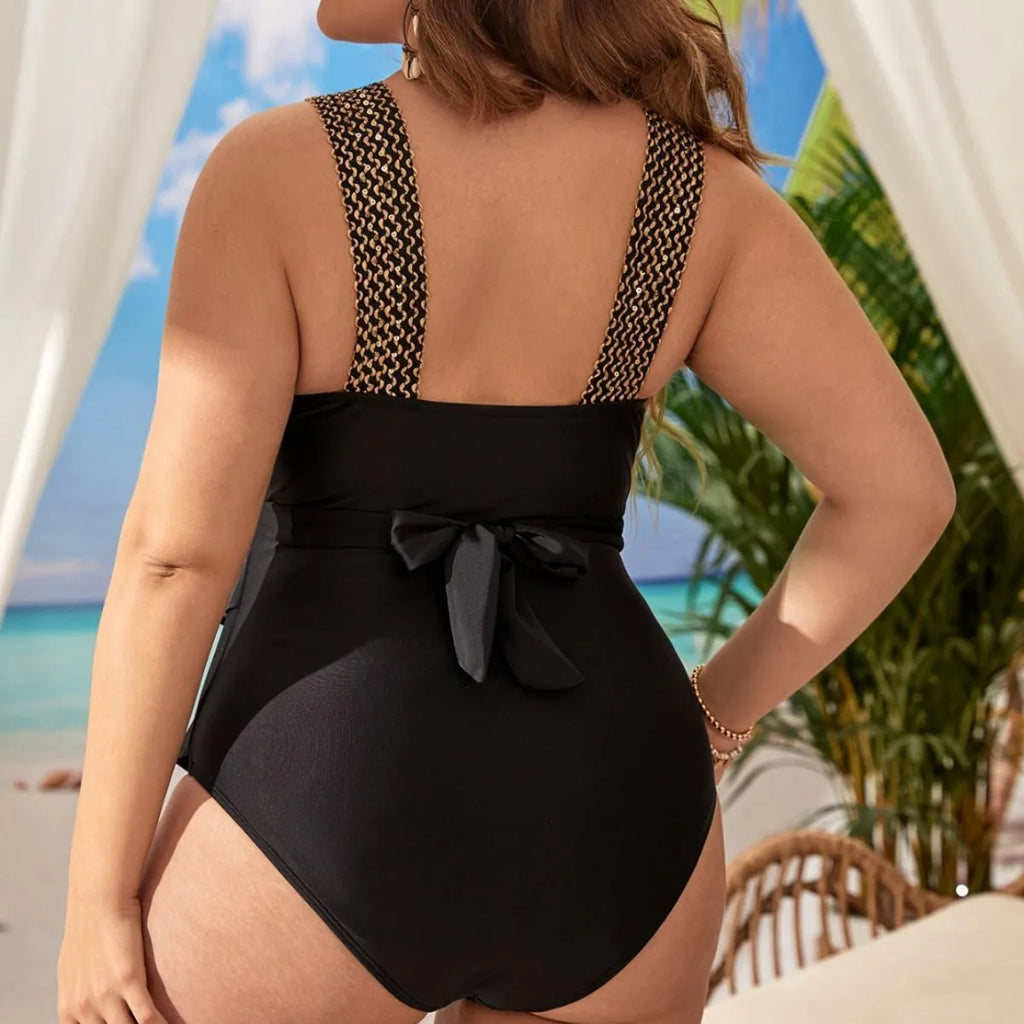 Women's black plus-size one-piece swimsuit with removable chest pad on a hanger.