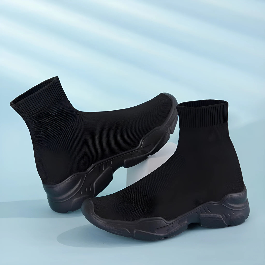Thick-soled slip-on casual shoes in black with fabric upper, mid-top design, and round toe.