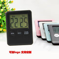 Black and white digital kitchen timer with magnetic back and display showing countdown time.