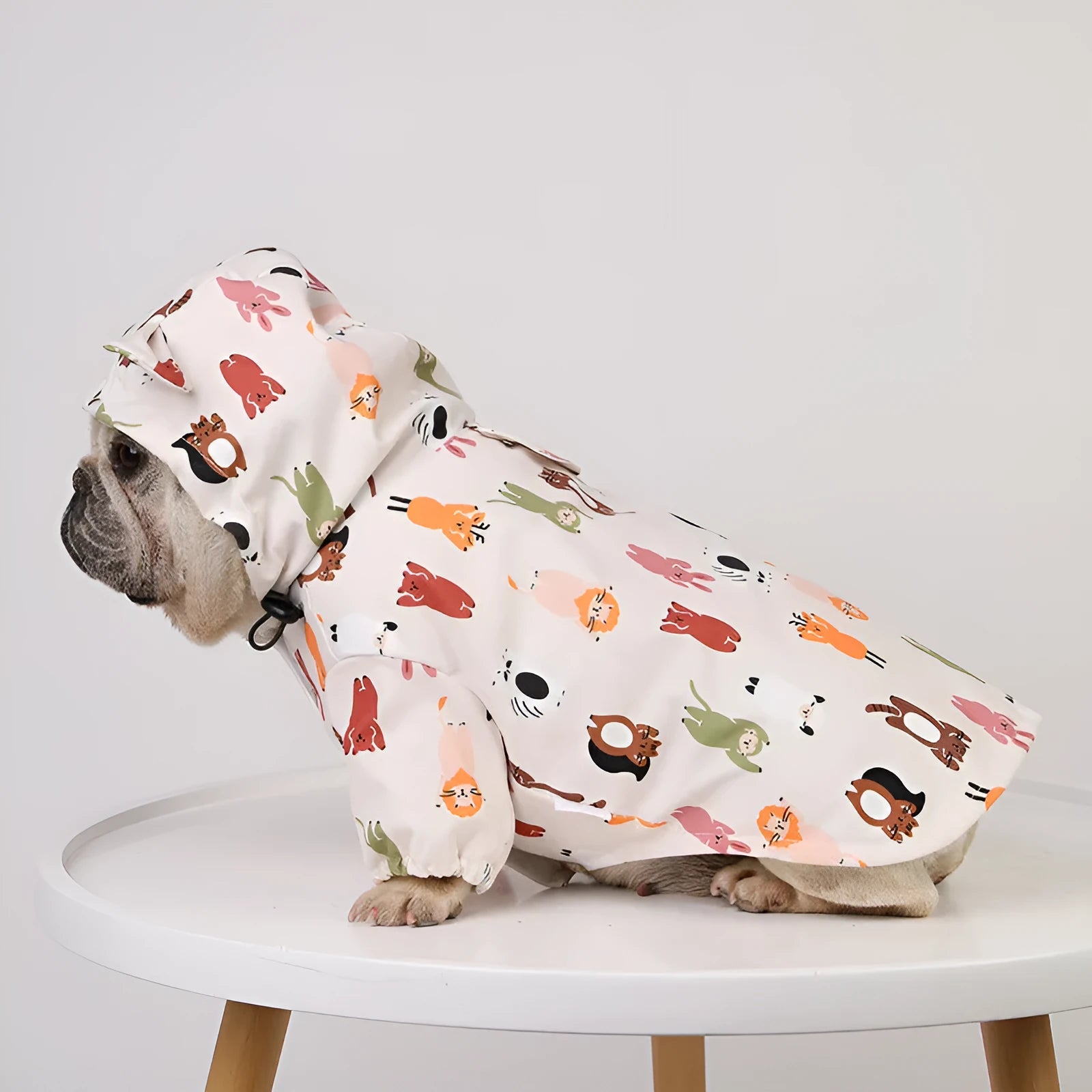 Beige dog raincoat with cartoon small animal print, showing PU waterproof material
