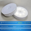 Small round white LED motion sensor night light with USB charging cable and adhesive tape