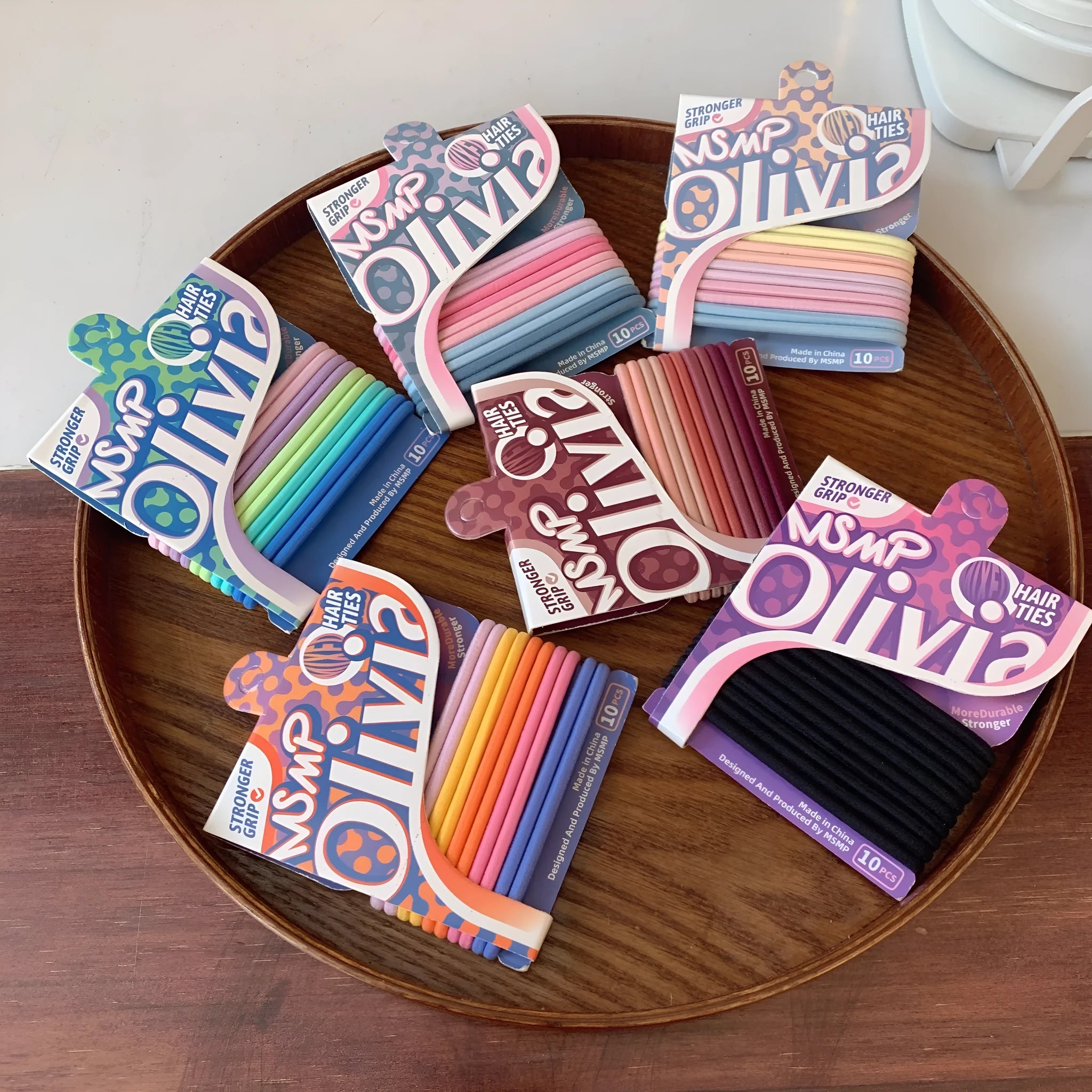 Assorted candy colour elastic hair bands with a braided design, shown holding a ponytail.