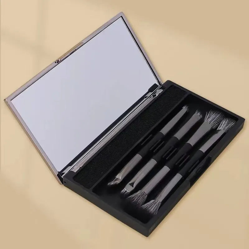 Portable makeup brush set with mirror showing gold or silver handled eyeshadow brushes.
