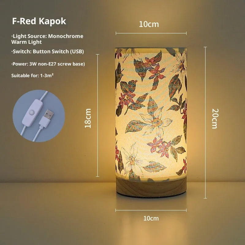 Creative floral fabric table lamp with remote control, warm LED light, black oil painting pattern on a bedside table