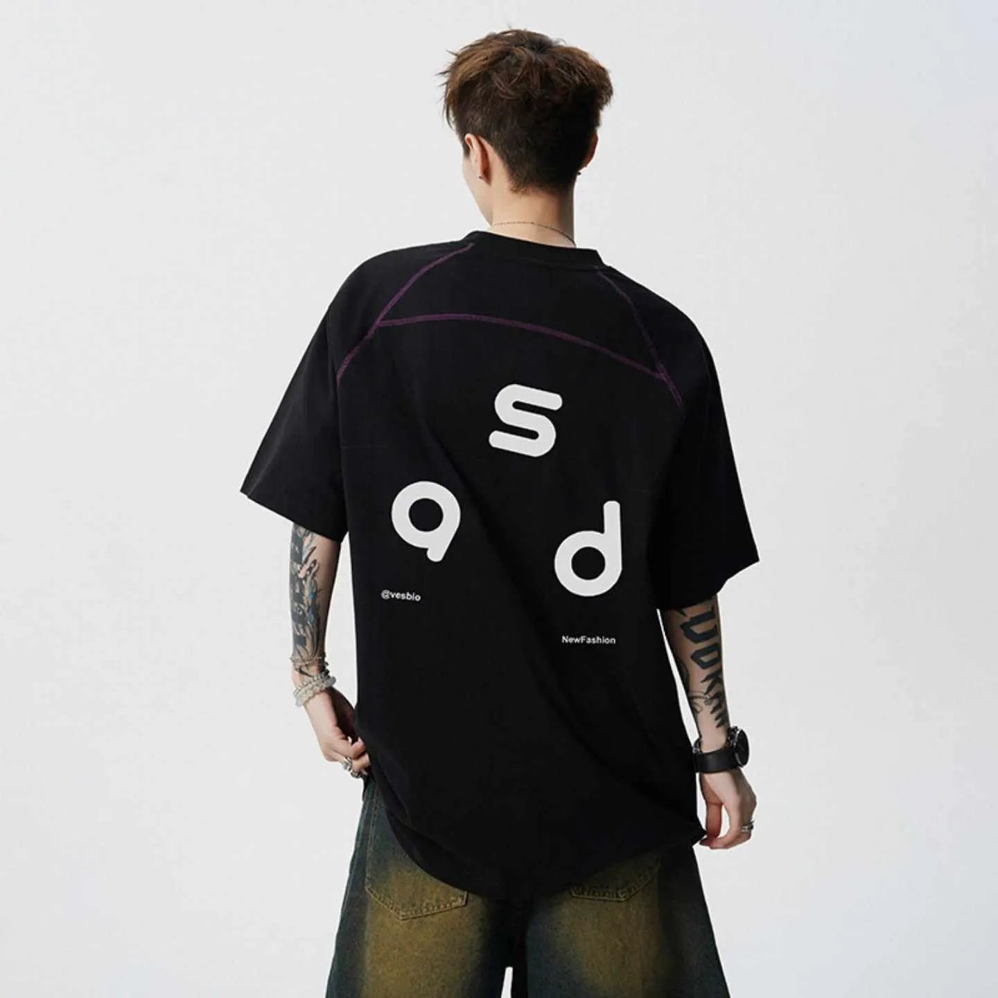 Men's loose-fit black cotton t-shirt with a white printed letter design on the front, showing short sleeves and a round neck.