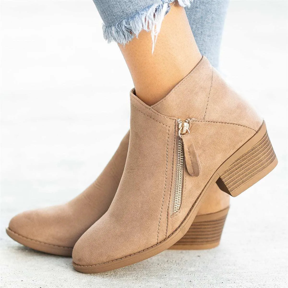 Women's beige suede ankle boots with a side zip and chunky heel on a white background.