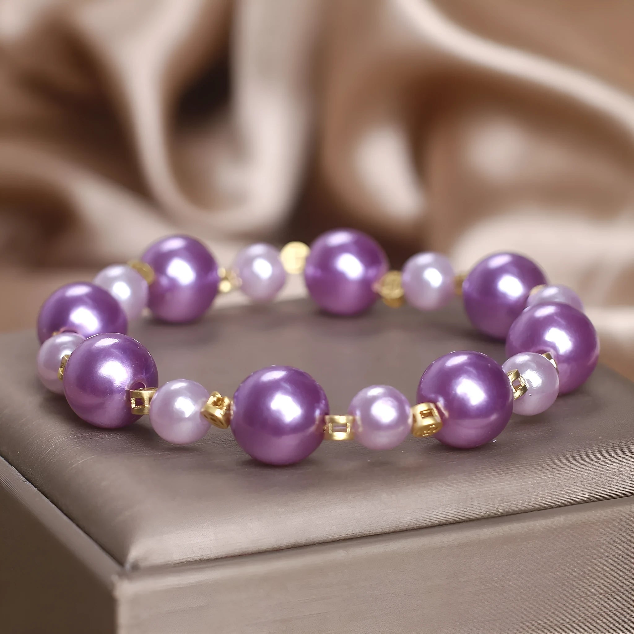 Purple shell pearl bracelet with letter coin accent on white background