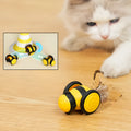 Pink and yellow bee-themed electric cat toy with feather attachment on floor