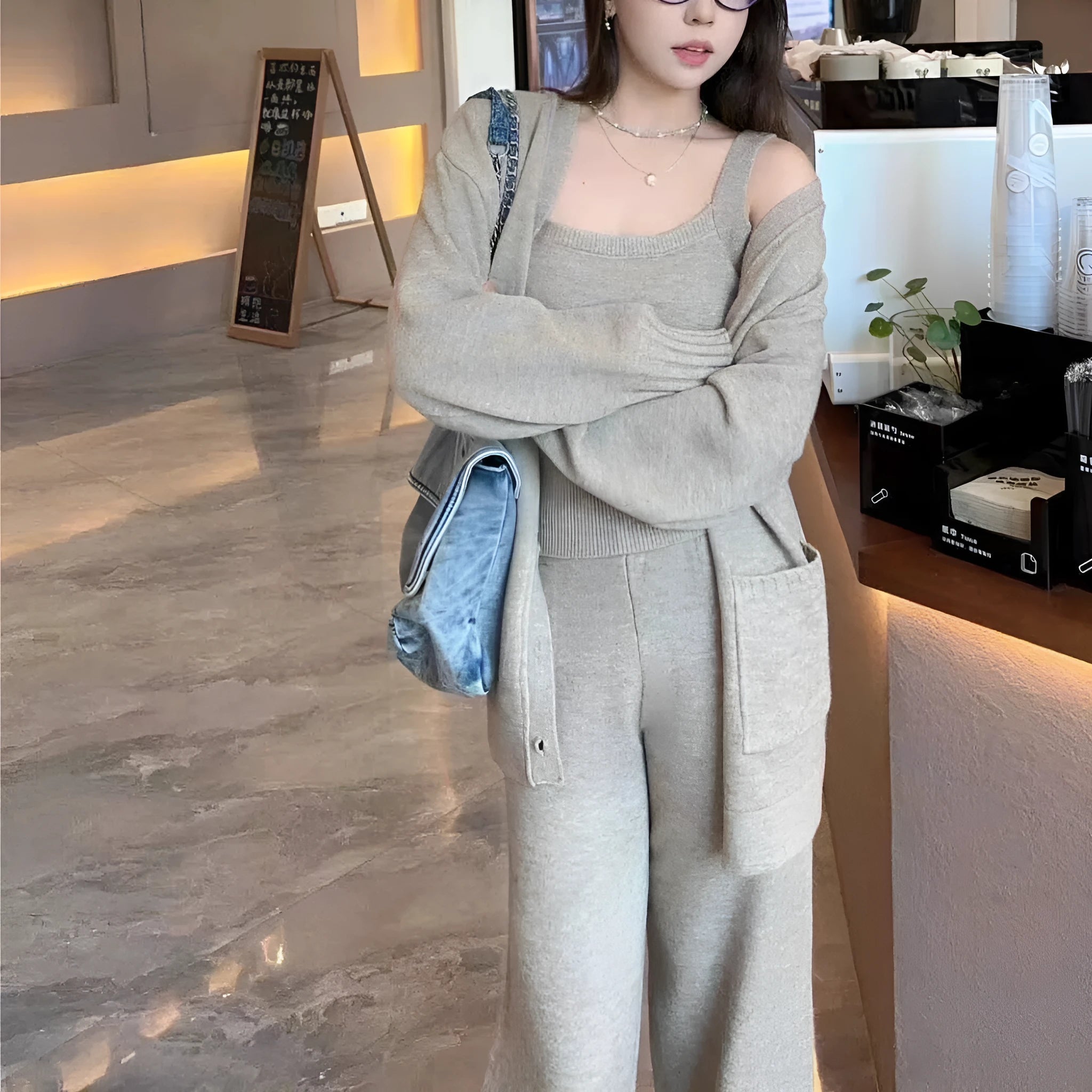 Women's light brown knit cardigan and suspender pants three-piece casual set on a hanger.
