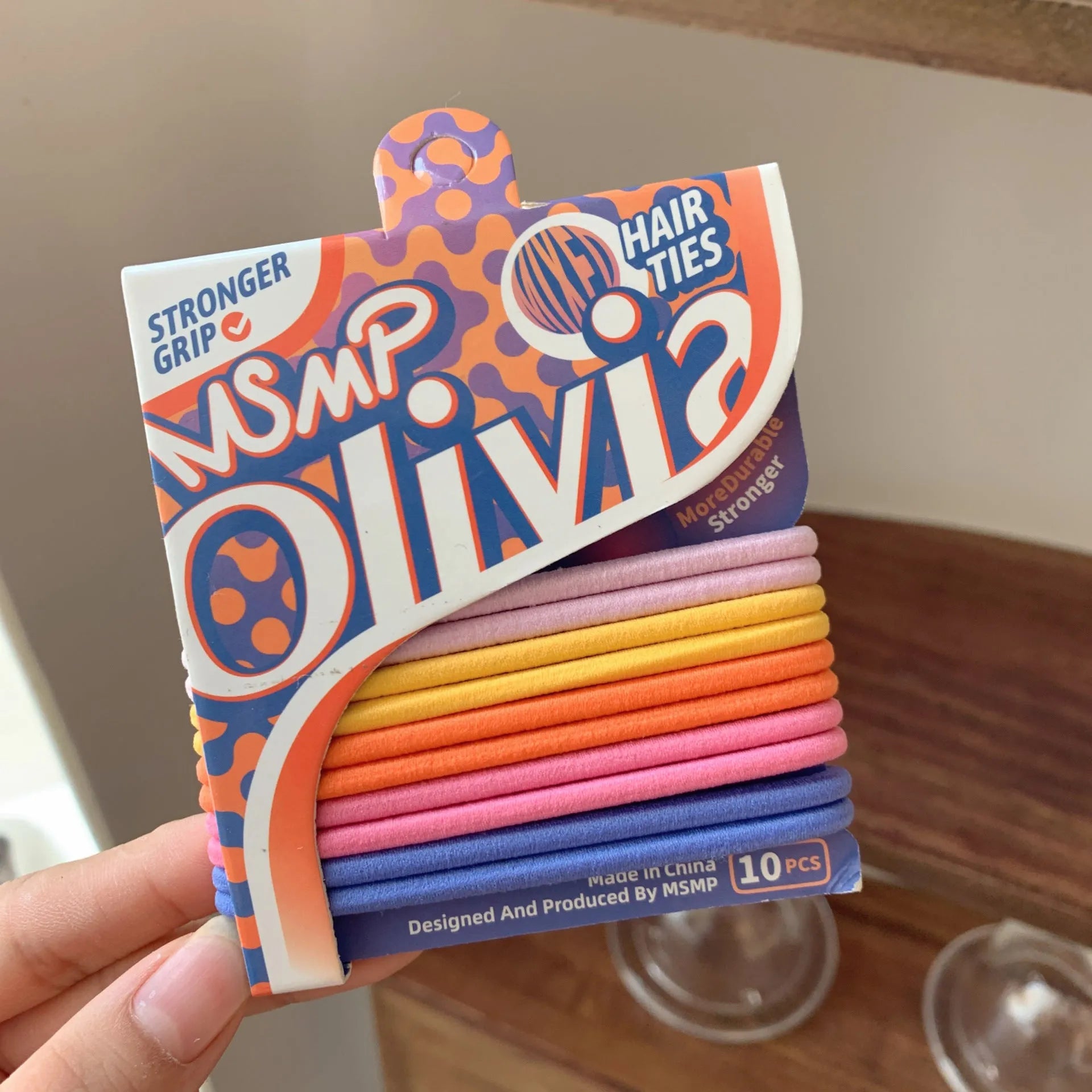 Assorted candy colour elastic hair bands with a braided design, shown holding a ponytail.