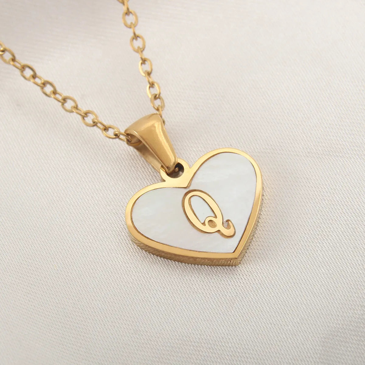Gold plated heart-shaped necklace with a personalised initial letter and white shell detail on a 50cm adjustable chain.