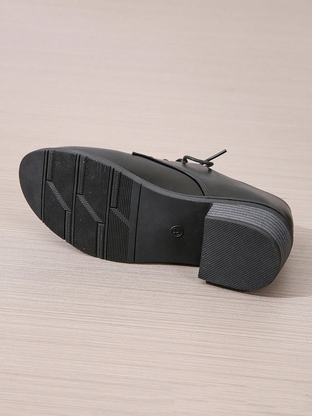 Black women's low-top work shoes with a chunky mid heel and soft rubber sole.