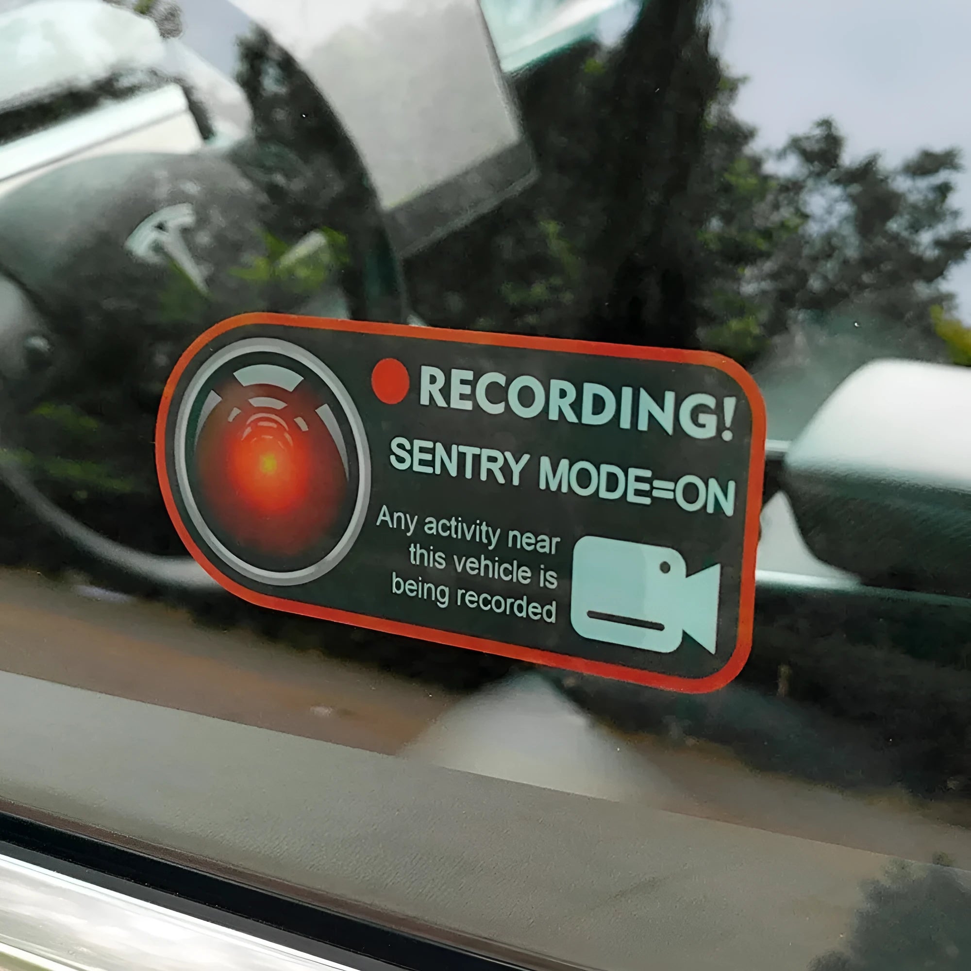 Pair of white electrostatic warning stickers for Tesla Sentry Mode on a car window.