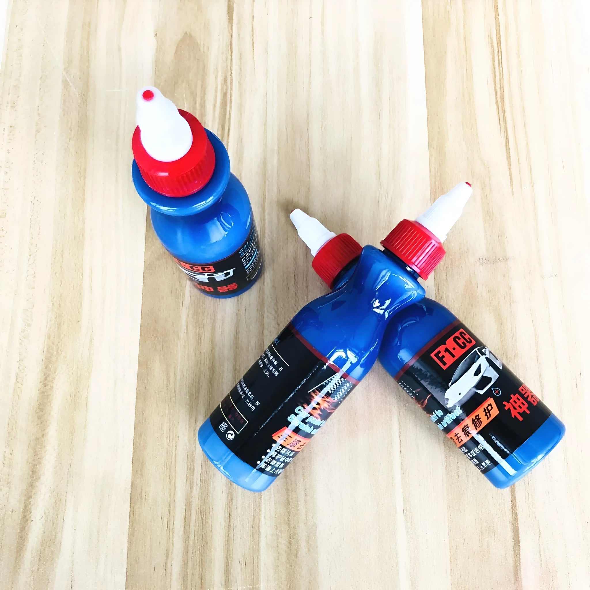 Small blue wiping tool and bottle of automotive scratch repair agent kit for car paint
