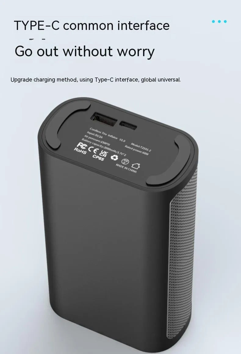 Handheld wireless digital tyre inflator with display screen, LED light, and multiple nozzle adaptors on a table.