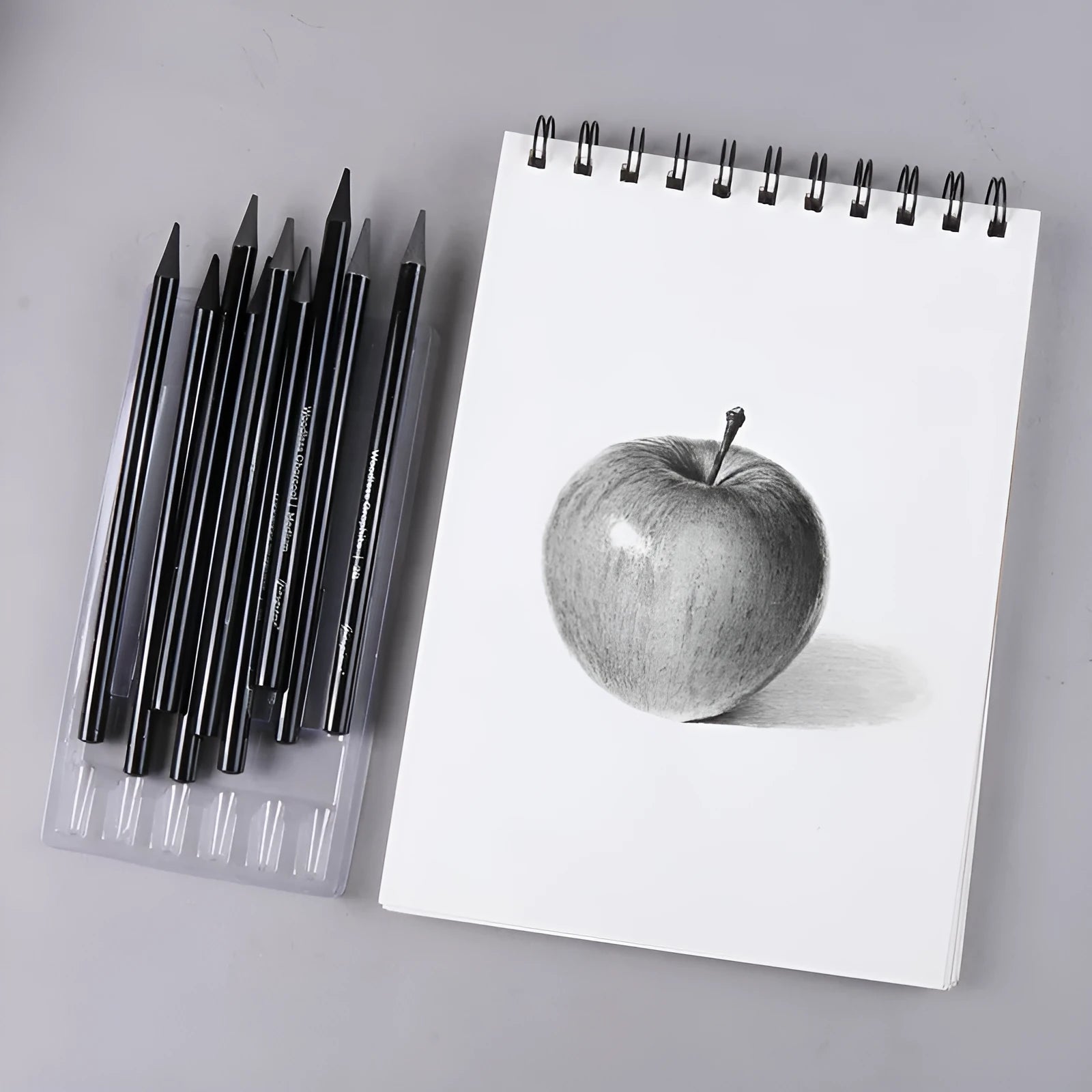 Set of six graphite pencils and three carbonized drawing pencils with wooden casings on a blister card.