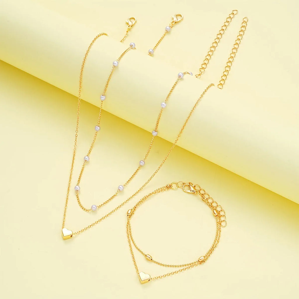 Double-layer stacked gold pearl heart necklace and bracelet jewelry set on display