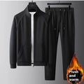 Man wearing a slim fit black stand collar sports suit with long sleeves and matching trousers.