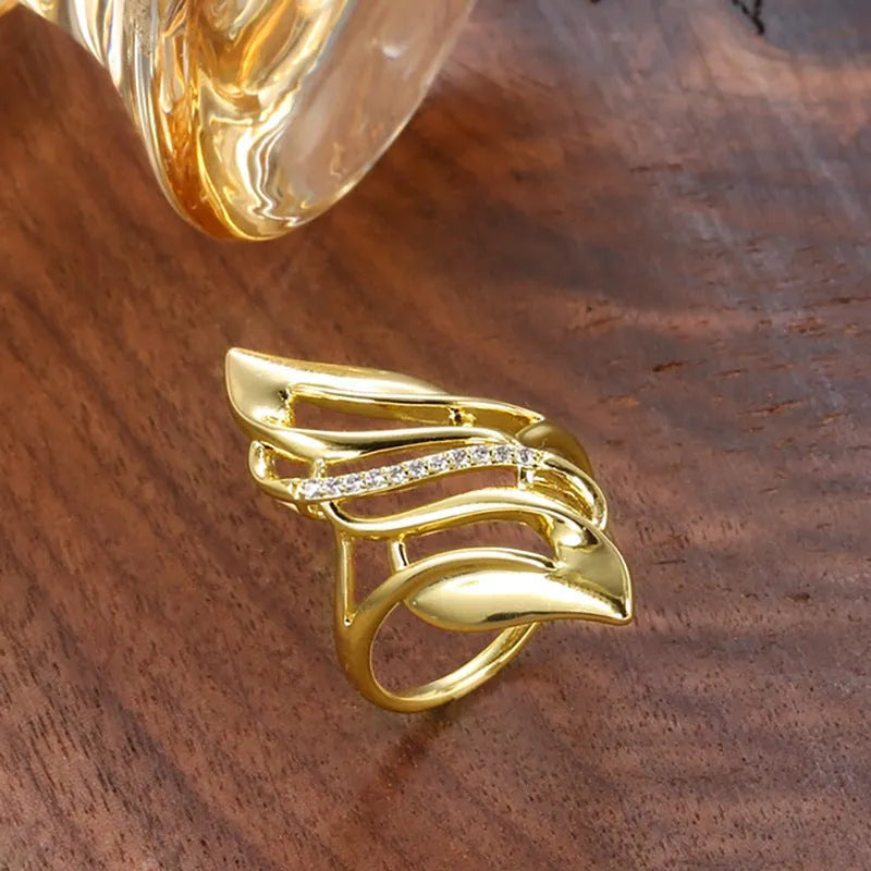 Gold copper women's ring with exaggerated curve silhouette and zircon sparkle on finger
