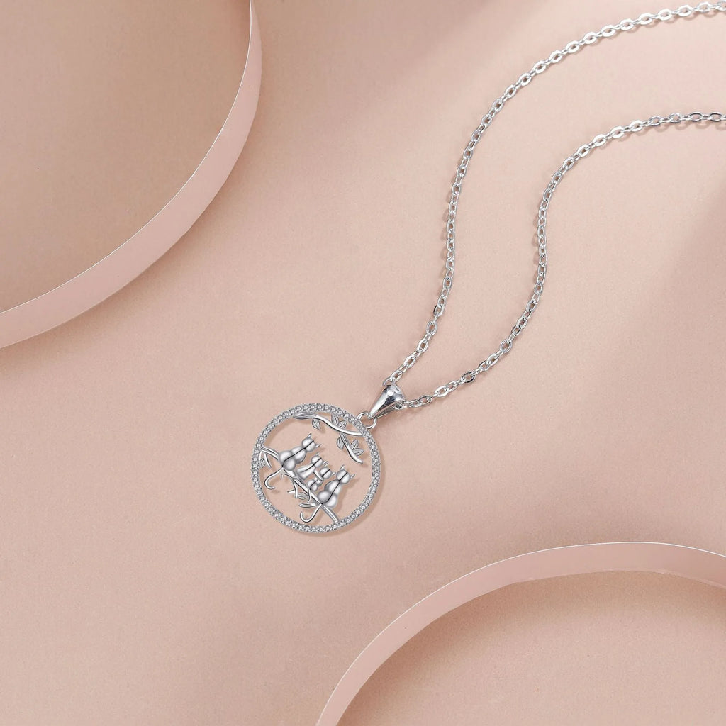 Four kitten pendant necklace on a copper cross chain with electroplated finish.
