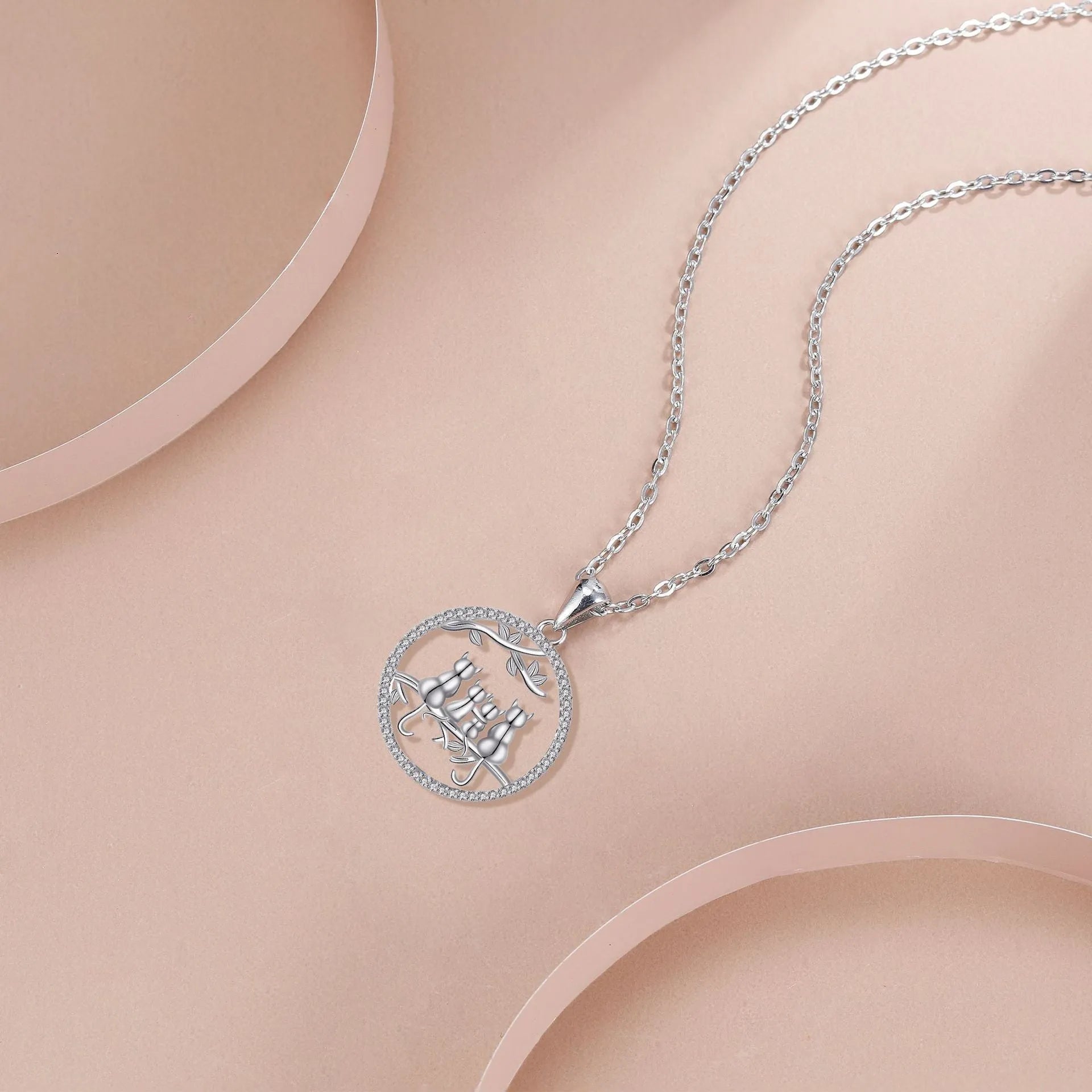 Four kitten pendant necklace on a copper cross chain with electroplated finish.