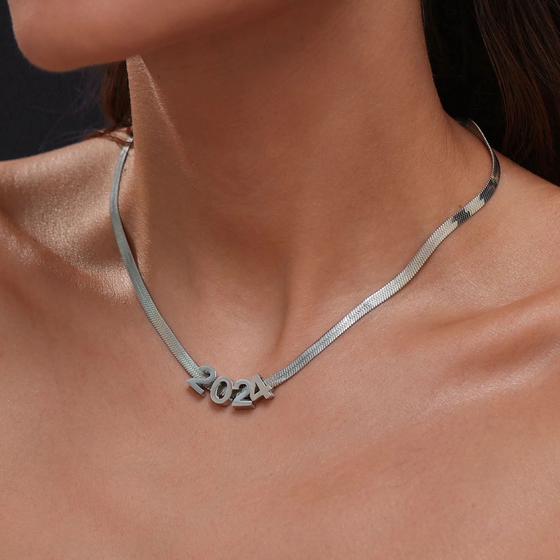 Gold and silver titanium steel necklaces showing letter A, number 7, and love heart charms on a 40.5cm chain.