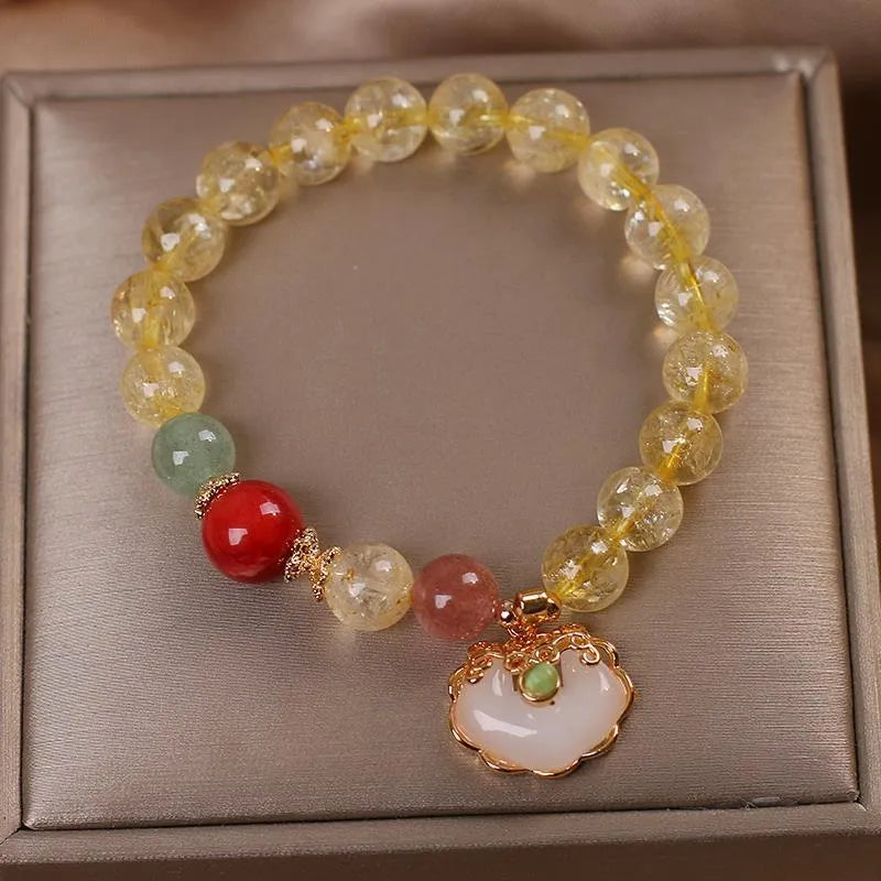 Women's bracelet with a citrine jade ruyi pendant and yellow hair crystal on an alloy band.
