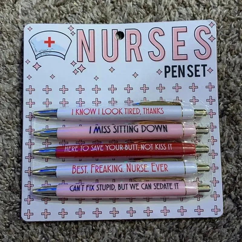 Set of five white plastic retractable ballpoint pens with blue and red nurse-themed humorous text printed on the barrels.
