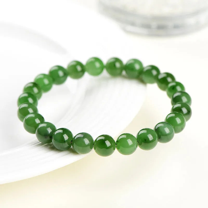 Polished Hetian jade bead bracelet in natural jasper colour on a wrist.