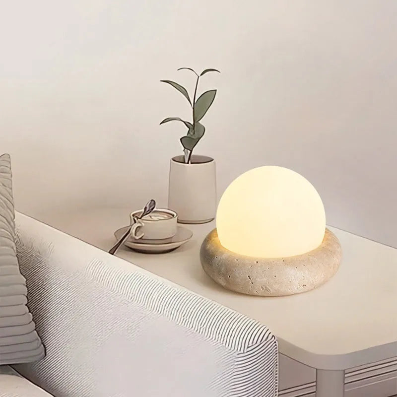 Cream coloured bedside night lamp with remote control on table