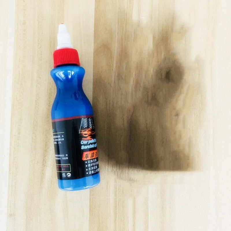 Small blue wiping tool and bottle of automotive scratch repair agent kit for car paint