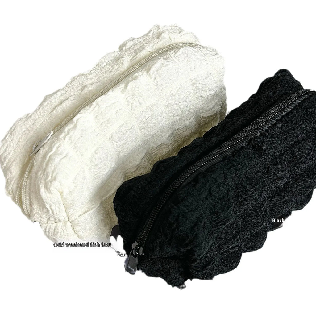 Cream puff style fabric pencil case in polyester construction showing beige and black colour options