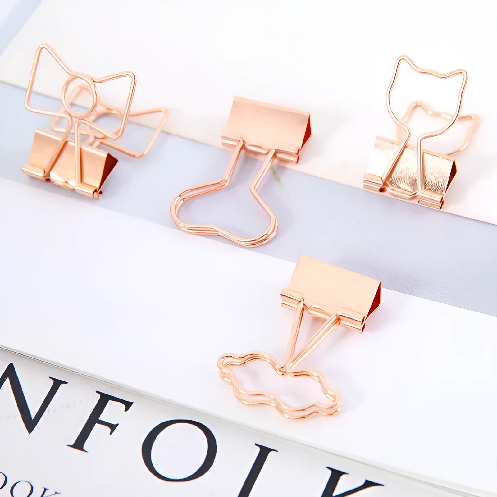 Gold metal decorative clip showing bow, cactus, cat, flamingo, and love shape designs.