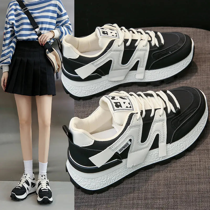 Black and white low-top lace-up sneakers with round toe and rubber sole