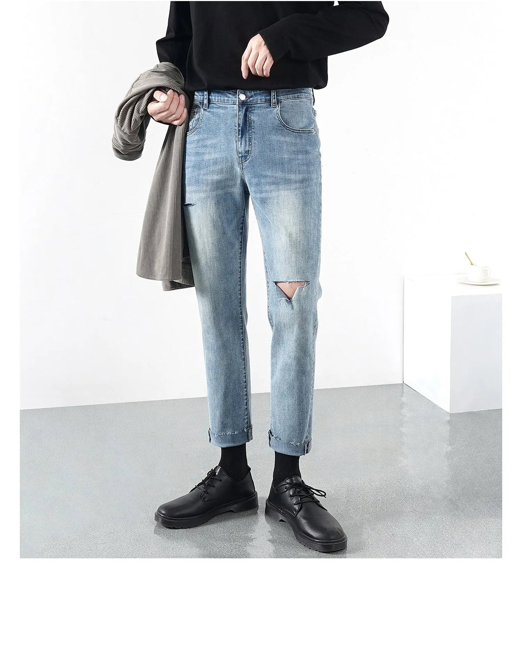 Men's light blue ripped jeans with microelastic cotton blend fabric, shown flat for size reference