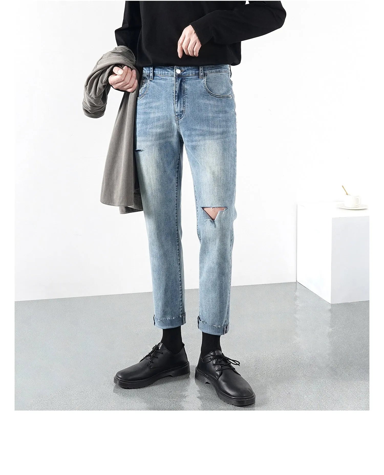 Men's light blue ripped jeans with microelastic cotton blend fabric, shown flat for size reference