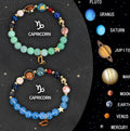 Set of two natural stone beaded bracelets for zodiac signs on a flat surface